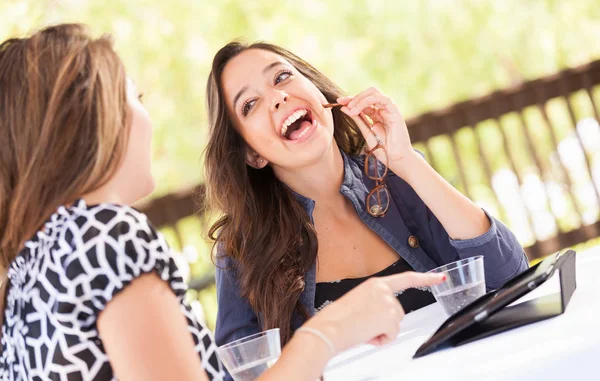 Expressive Young Adult Girlfriends Using Their Computer Electronics Outdoors Stock Image