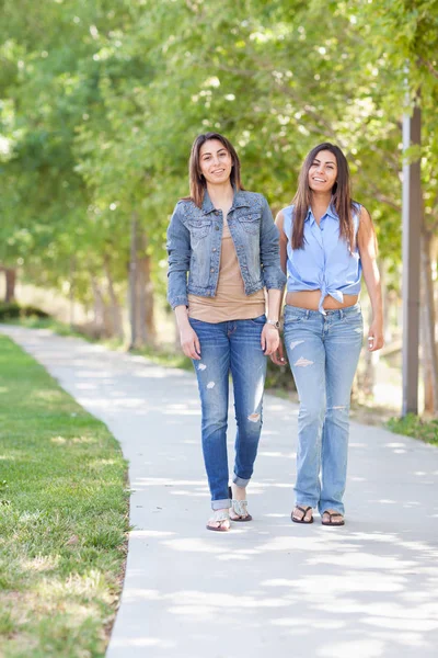 Två vackra etniska tvillingsystrar promenader utomhus. — Stockfoto