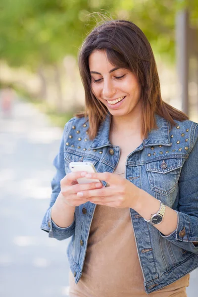 Vacker ung etniska kvinna använder sin Smartphone-utsidan. — Stockfoto