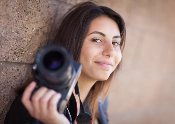 Jovem adulto étnico fotógrafo feminino contra parede segurando câmera — Fotografia de Stock