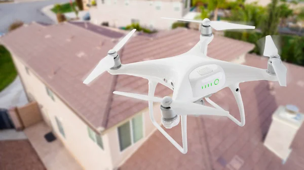 Sistema de aviones no tripulados (UAV) Quadcopter Drone In The Air Over House Inspeccionando el techo . —  Fotos de Stock