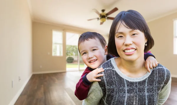 Chinese moeder en gemengd ras kind binnen lege kamer van nieuwe huis — Stockfoto