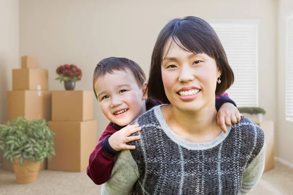 Cinese madre e misto razza bambino dentro vuoto stanza con movin — Foto Stock