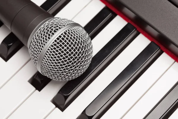 Pose du microphone sur le clavier du synthétiseur électronique Résumé — Photo