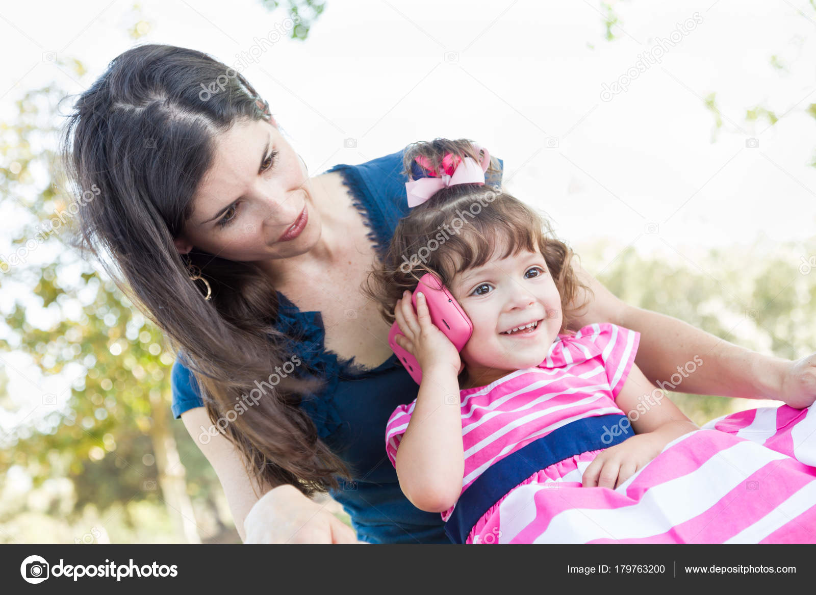 Mixed Race Mother And Cute Baby Daughter Playing With Cell Phone In