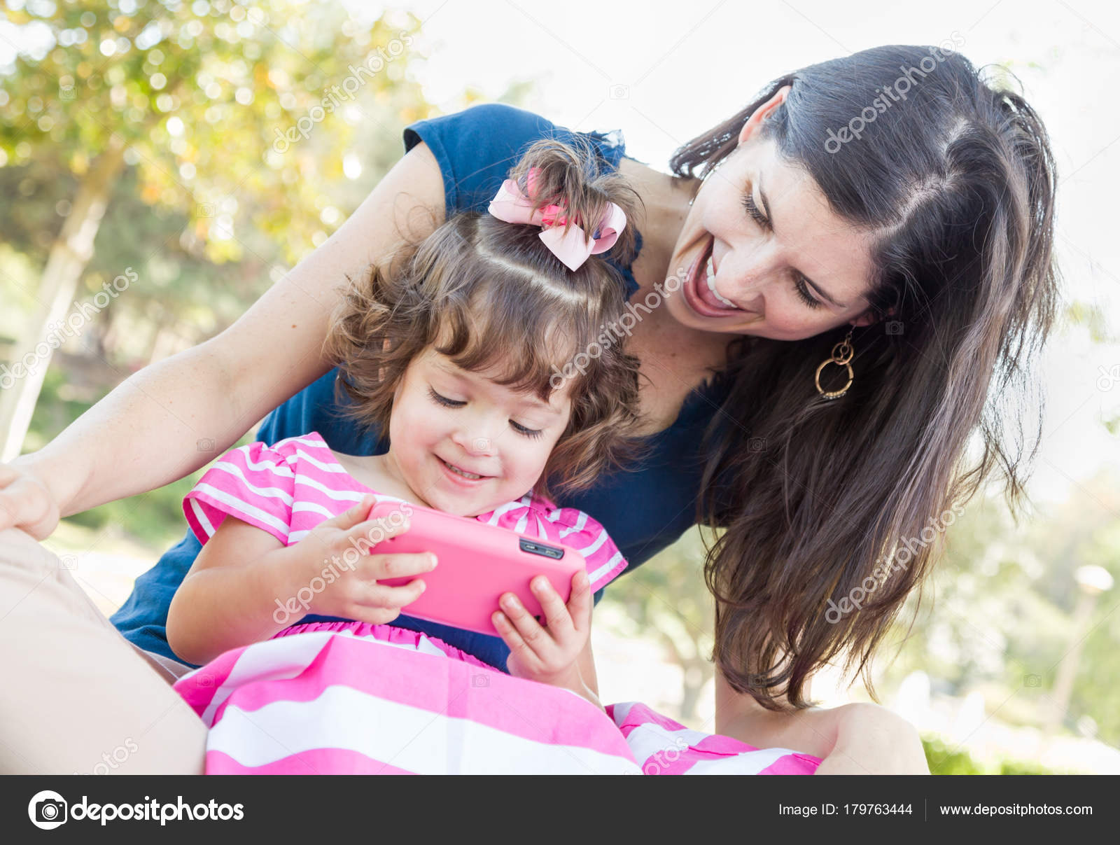 Mixed Race Mother And Cute Baby Daughter Playing With Cell Phone In