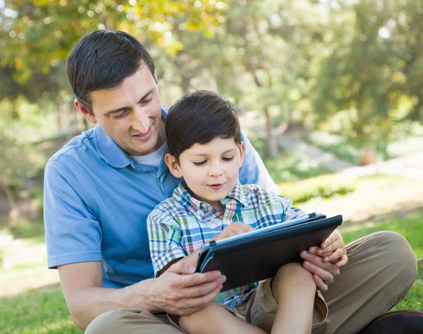 Padre e hijo felices jugando en una tableta de computadora afuera . —  Fotos de Stock
