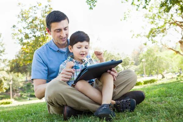 Happy Father and Son Playing on a Computer Tablet Outside. — Stock Photo, Image