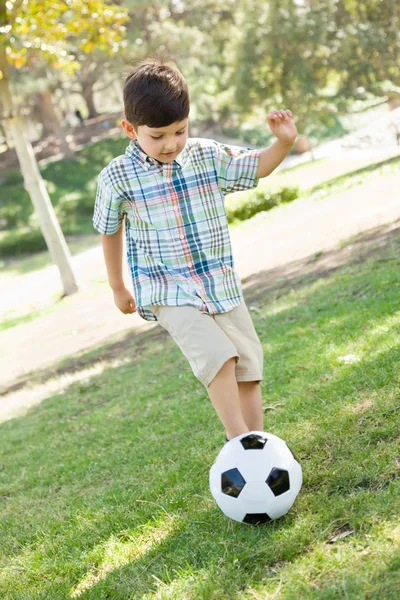 屋外、公園でサッカー ボールで遊ぶかわいい少年. — ストック写真