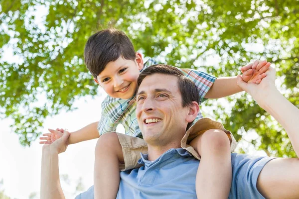 Raza mixta Padre e hijo jugando a caballito juntos en el parque — Foto de Stock