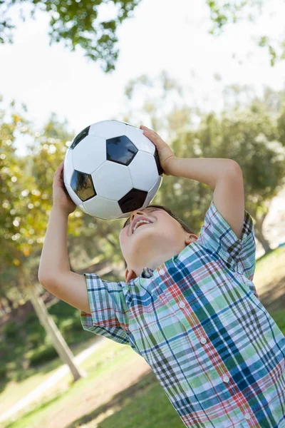 Draguta tanar baiat joc cu mingea de fotbal în aer liber în the parc . — Fotografie, imagine de stoc
