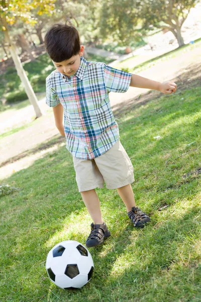 Schattige jongen speelt met voetbal buiten in het park. — Stockfoto