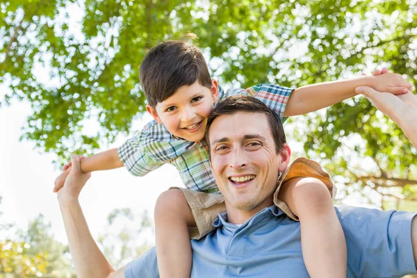 Karışık ırk baba ve oğul birlikte parkta oynarken sırtına — Stok fotoğraf