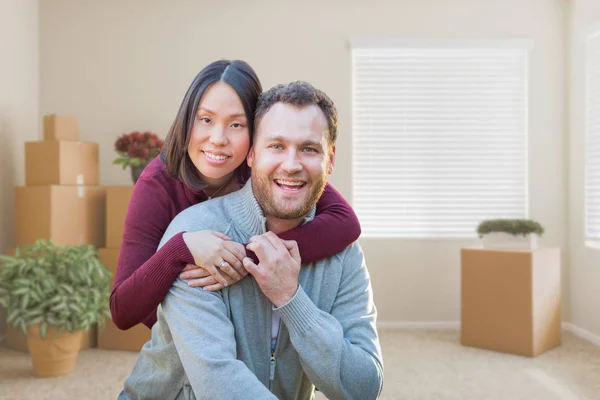 Razza mista caucasico e cinese coppia all'interno stanza vuota con scatole mobili . — Foto Stock