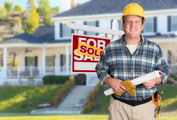 Entreprenör med planer och hård hatt framför säljs för försäljning fastigheter tecken och hus. — Stockfoto