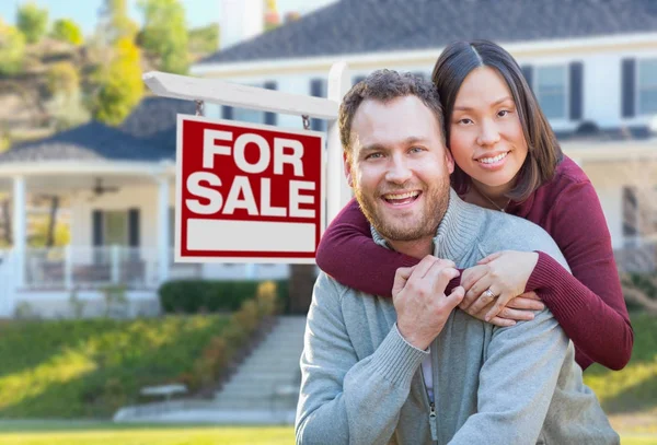 Mixed Race Caucasian and Chinese Couple In Front of For Sale Real Estate Sign and House. — Stock Photo, Image