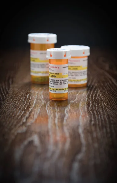 Variety of Non-Proprietary Prescription Medicine Bottles on Reflective Wooden Surface. — Stock Photo, Image