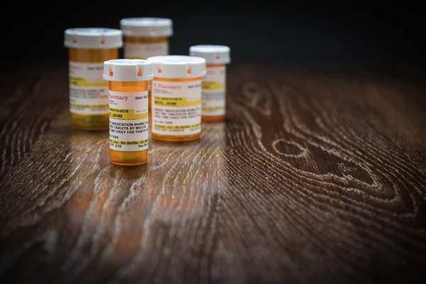 Verscheidenheid van niet-merkgebonden recept geneeskundeflessen op reflecterende houten oppervlak. — Stockfoto