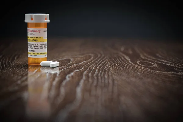 Botella y píldoras de medicina de prescripción no patentada en superficie de madera reflectante . — Foto de Stock