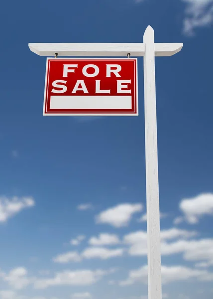 Vlevo směrem na prodej nemovitostí znamení na modrou oblohu s mraky. — Stock fotografie