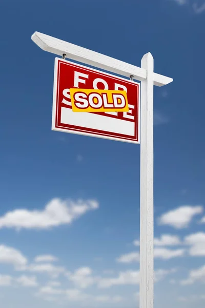 Sol bakan Satılık Emlak işareti mavi bir gökyüzü bulutlu satılıyor. — Stok fotoğraf