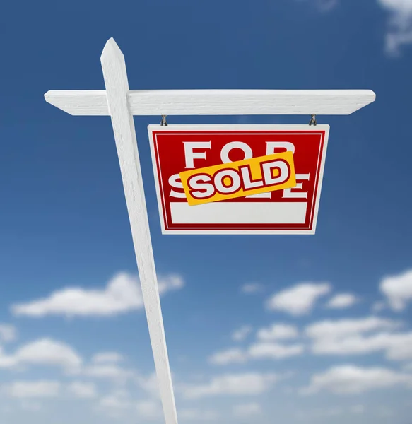 Rechterpagina verkocht voor verkoop onroerend goed teken op een blauwe hemel met wolken. — Stockfoto