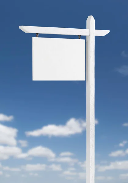 Blank Real Estate Sign Over A Blue Sky with Clouds. Stock Image