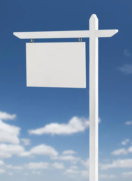 Blank Real Estate Sign Over A Blue Sky with Clouds. Royalty Free Stock Photos