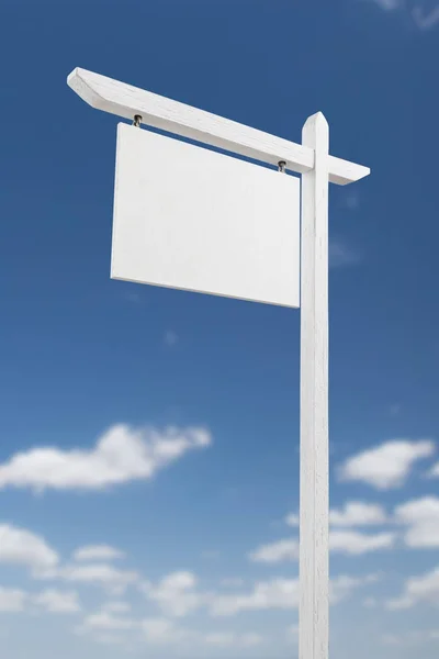 Blank Real Estate Sign Over A Blue Sky with Clouds. Royalty Free Stock Photos