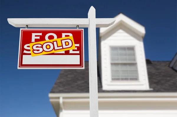 Sol bakan Satılık Emlak işareti ev ve derin mavi gökyüzü önünde satılıyor. — Stok fotoğraf