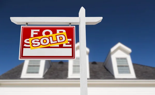 Links gegenüber verkauft Immobilienschild vor dem Haus und tiefblauer Himmel. — Stockfoto