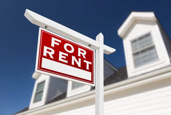 Links zur Miete Immobilienschild vor dem Haus und tiefblauer Himmel. — Stockfoto