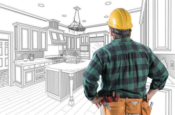 Empreiteiro masculino com chapéu duro e cinto de ferramentas olhando para o desenho da cozinha personalizada em branco . — Fotografia de Stock