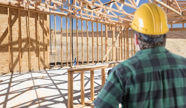 Entrepreneur debout à l'intérieur du cadre de construction de la nouvelle maison . — Photo