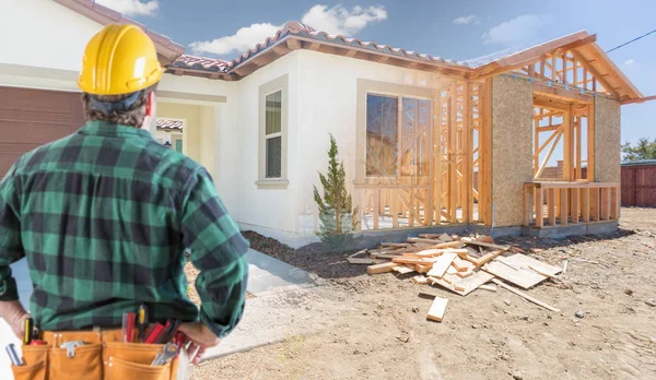 Bauunternehmer steht vor Baurahmen und Foto des neuen Hauses. — Stockfoto