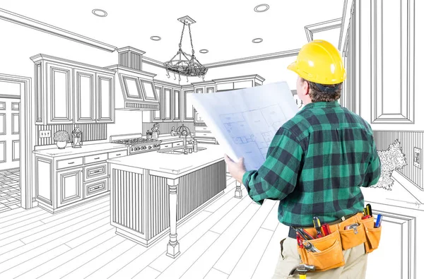 Мужчина-подрядчик в жесткой шляпе и планы глядя на обычную кухню рисование на белом . — стоковое фото