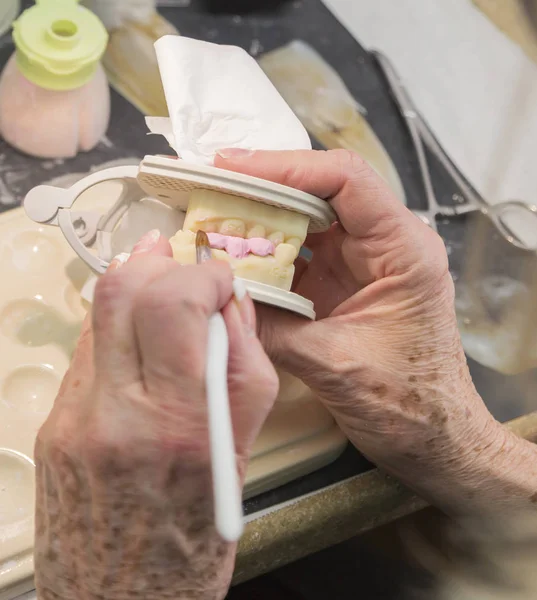 Técnico dental que aplica la porcelana al molde de implante impreso en 3D — Foto de Stock