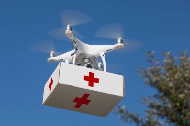 İnsansız uçak sistemi (Uas) Quadcopter havada ilk yardım paketi taşıyan uçak.
