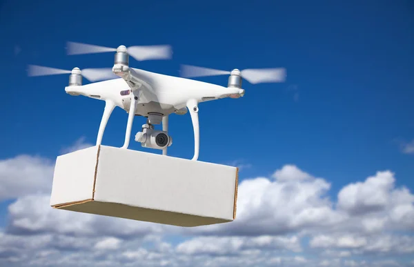 Sistema de aviones no tripulados (UAS) Quadcopter Drone que lleva el paquete en blanco en el aire . —  Fotos de Stock
