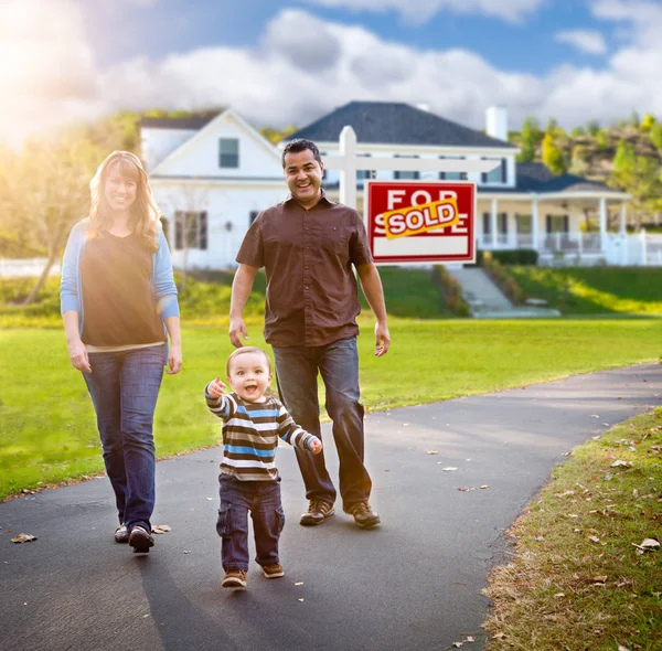 Glücklich gemischte Rasse Familie zu Fuß vor dem Haus und verkauft zum Verkauf Zeichen — Stockfoto