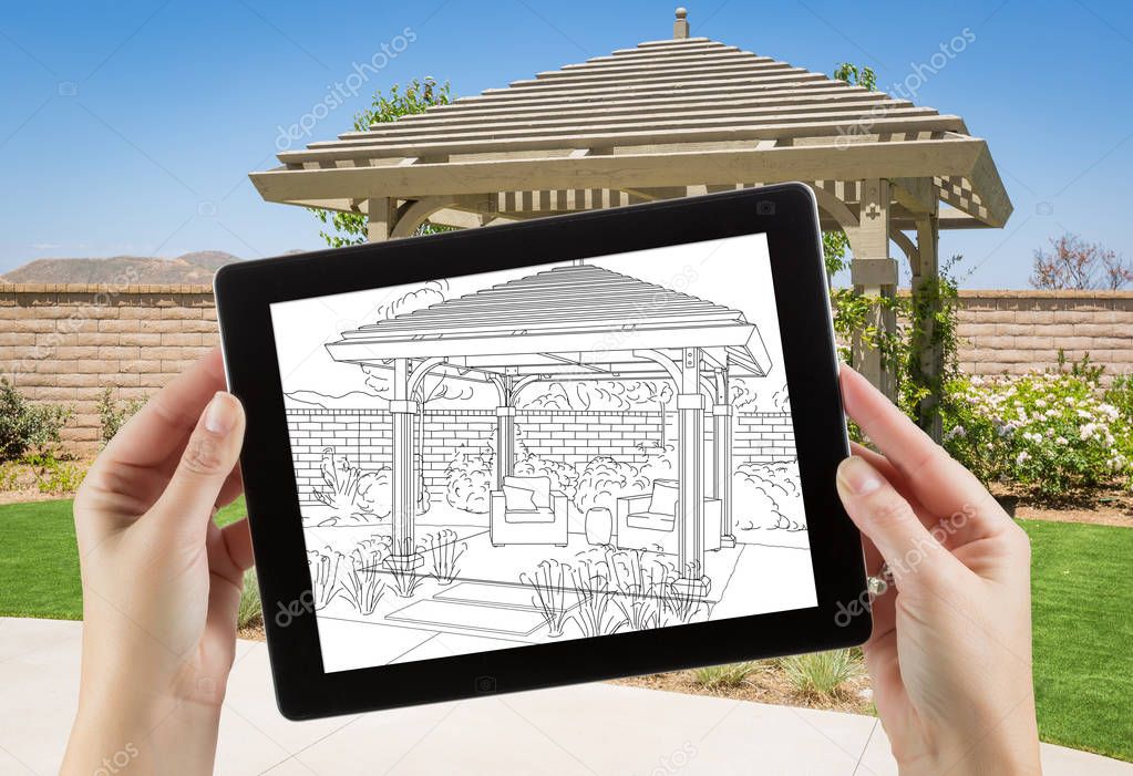 Female Hands Holding Computer Tablet with Drawing of Pergola on Screen, Photo Behind.