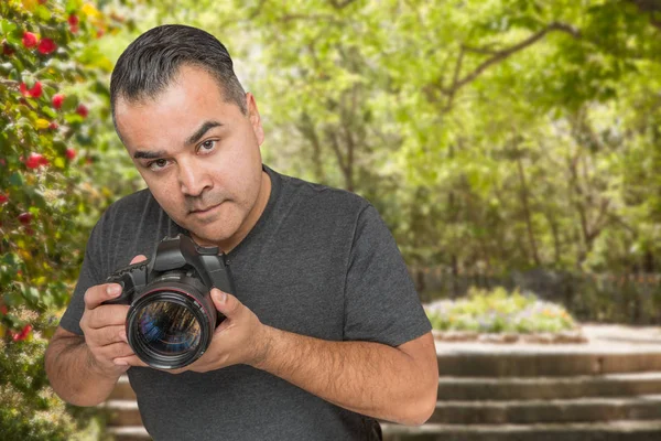 Hispanische junge männliche Fotograf mit DSLR-Kamera im Freien — Stockfoto