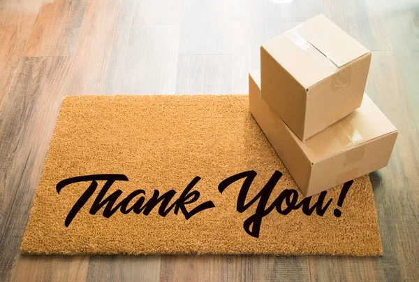 Obrigado tapete de boas-vindas no chão de madeira com expedição de caixas — Fotografia de Stock
