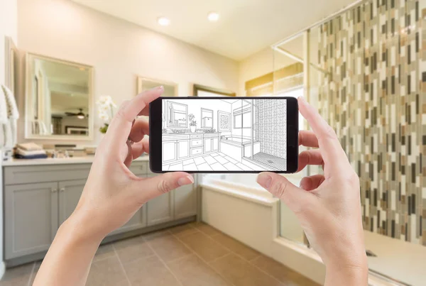 Handen met slimme telefoon met Master badkamer tekening op het scherm en foto achter. — Stockfoto