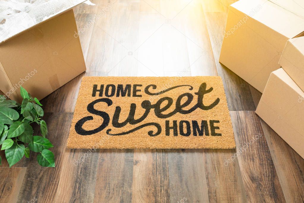 Home Sweet Home Welcome Mat, Moving Boxes and Plant on Hard Wood Floors.
