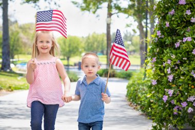 Genç kız ve erkek kardeş parkta Amerikan bayrakları sallayarak