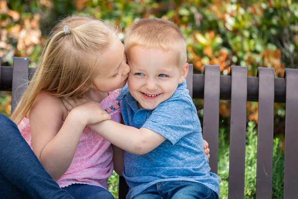 Jonge zus en broer plezier op de Bank in het Park — Stockfoto