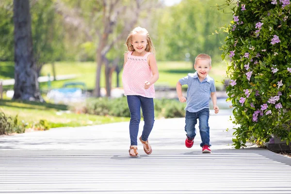 Kleine Schwester und Bruder haben Spaß beim Laufen im Park — Stockfoto