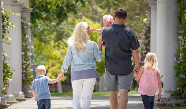 Jovem família caucasiana dando um passeio no parque — Fotografia de Stock