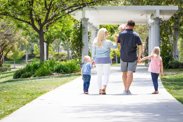 Jovem família caucasiana dando um passeio no parque — Fotografia de Stock